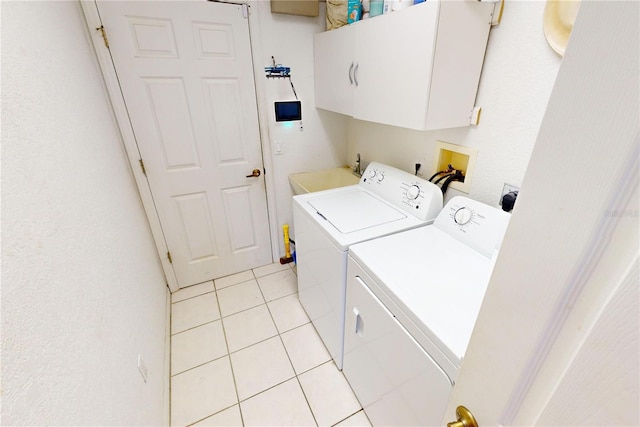 laundry area featuring washer and dryer, cabinets, light tile patterned floors, and sink