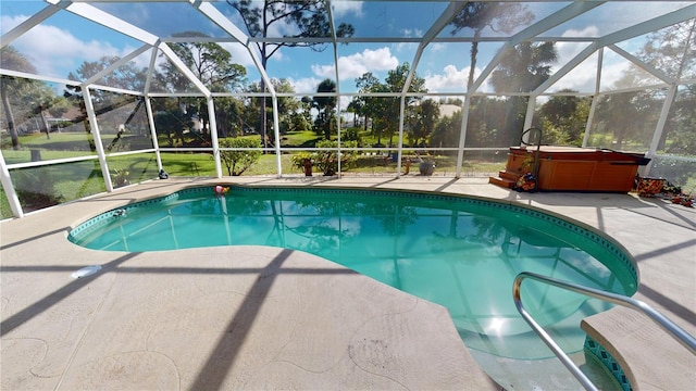 view of swimming pool featuring glass enclosure, a patio, and a hot tub