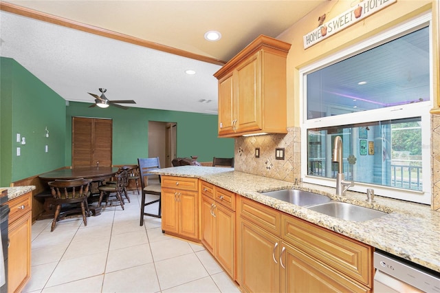 kitchen with backsplash, light tile patterned floors, sink, stainless steel dishwasher, and ceiling fan