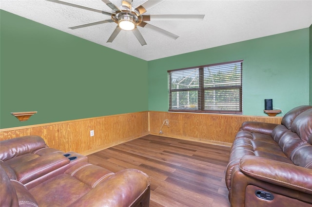 living room featuring wood walls, hardwood / wood-style floors, and a textured ceiling