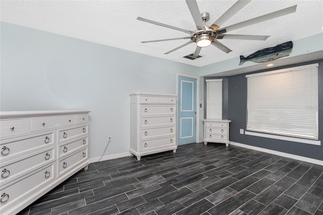 unfurnished bedroom featuring ceiling fan, dark hardwood / wood-style floors, and a textured ceiling