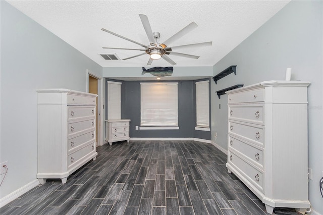 unfurnished bedroom featuring dark wood-type flooring, a textured ceiling, and ceiling fan