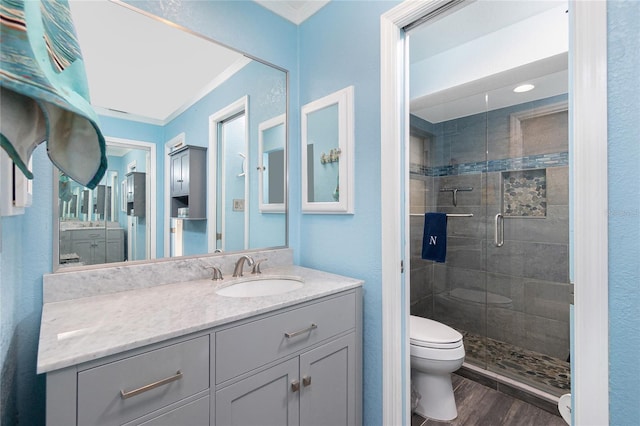 bathroom featuring hardwood / wood-style floors, vanity, an enclosed shower, crown molding, and toilet