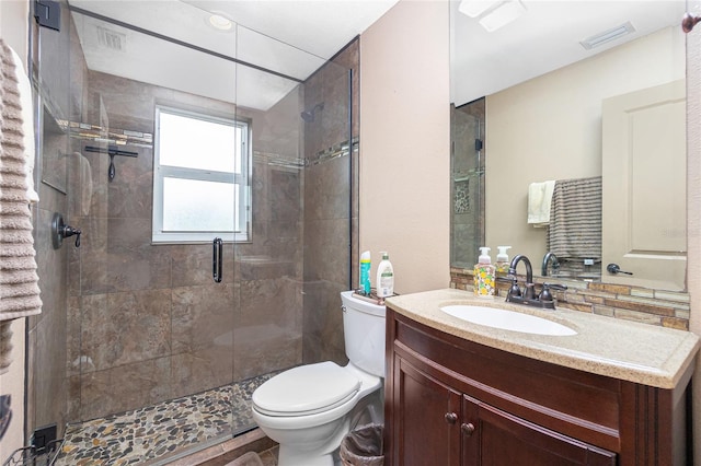 bathroom with an enclosed shower, vanity, and toilet