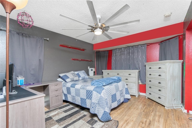 bedroom featuring ceiling fan, a textured ceiling, and light hardwood / wood-style flooring