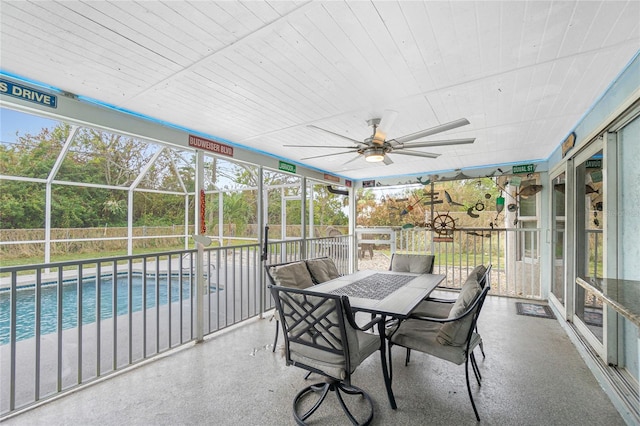 unfurnished sunroom with ceiling fan