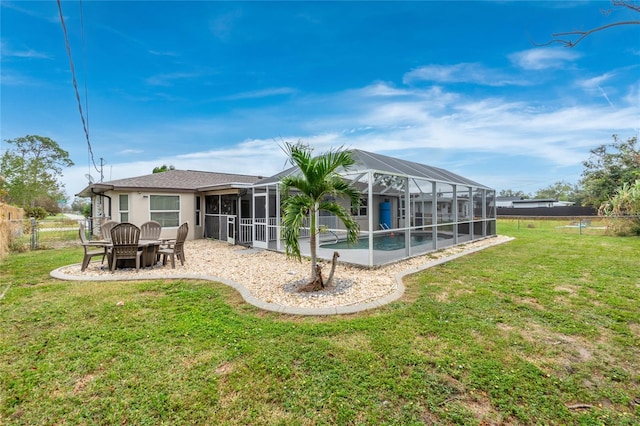 rear view of property with a lanai, a lawn, and a patio