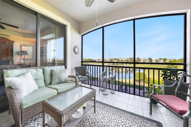 sunroom / solarium with a water view and ceiling fan