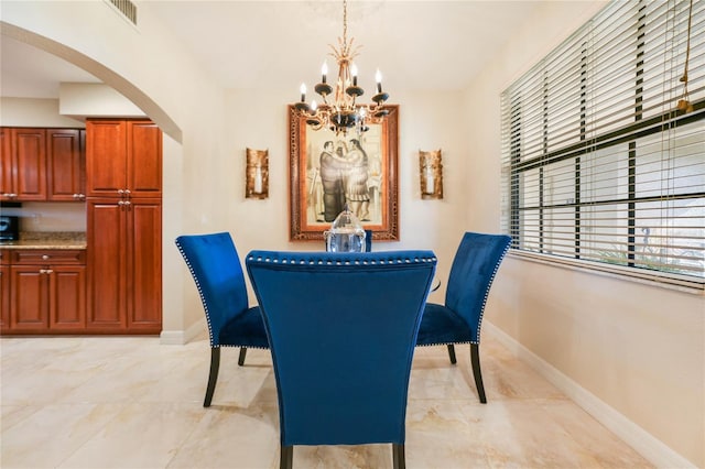 dining room with visible vents, arched walkways, a chandelier, and baseboards