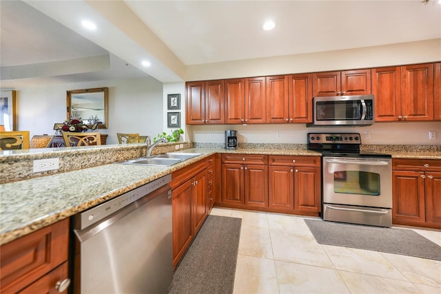 kitchen with appliances with stainless steel finishes, sink, light stone counters, and light tile patterned floors