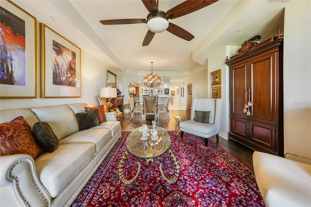 living room featuring ceiling fan with notable chandelier and dark hardwood / wood-style floors