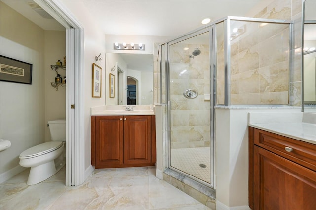 bathroom featuring toilet, an enclosed shower, and vanity