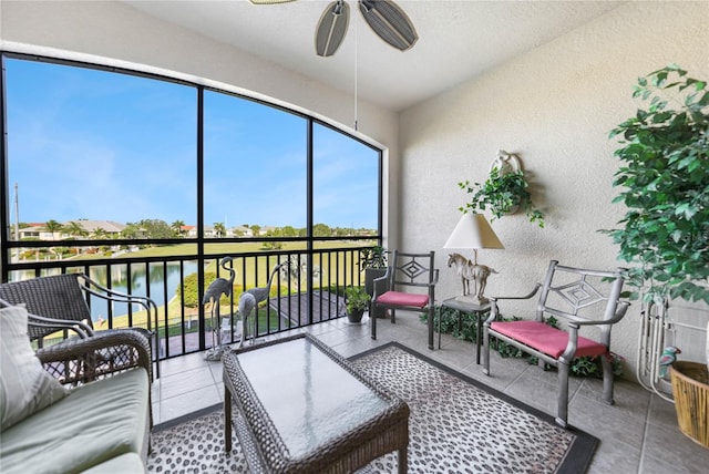 sunroom / solarium featuring ceiling fan and a water view