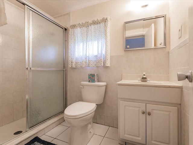 bathroom featuring vanity, a shower with door, tile patterned floors, and tile walls