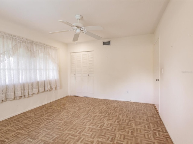 spare room featuring light parquet floors and ceiling fan