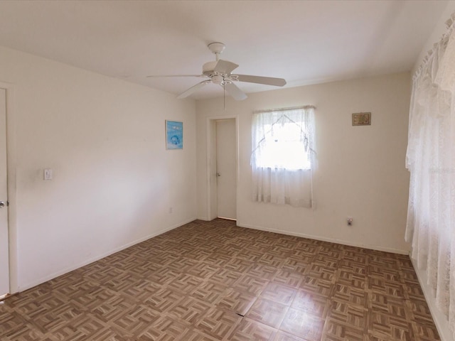 spare room featuring parquet flooring and ceiling fan