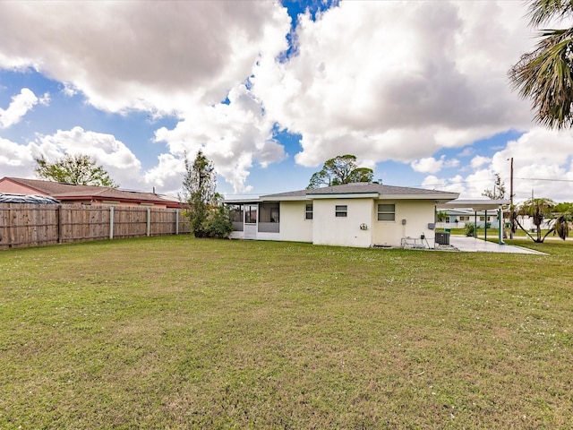 rear view of property featuring a yard and a patio area