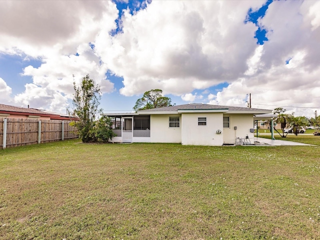 rear view of property with a sunroom and a lawn