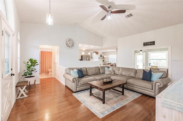 living room featuring hardwood / wood-style floors, vaulted ceiling, and ceiling fan