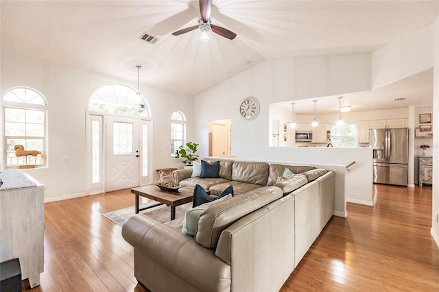 living room featuring vaulted ceiling, ceiling fan, and light hardwood / wood-style flooring