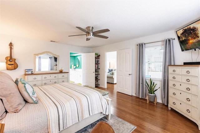 bedroom featuring hardwood / wood-style flooring, ceiling fan, and multiple windows