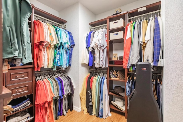 walk in closet with light hardwood / wood-style floors