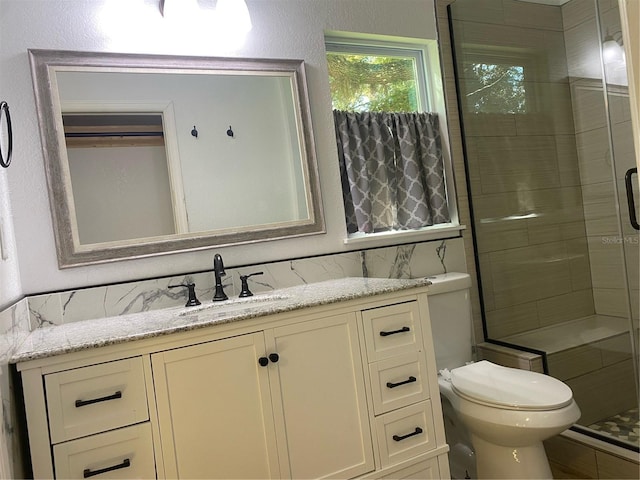 bathroom with walk in shower, vanity, and toilet