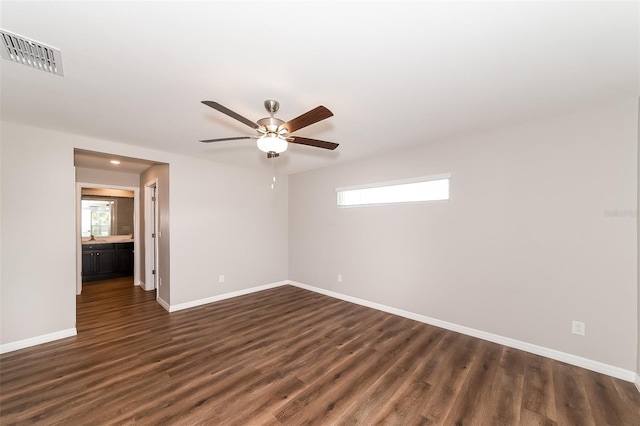 empty room featuring dark wood-type flooring and ceiling fan