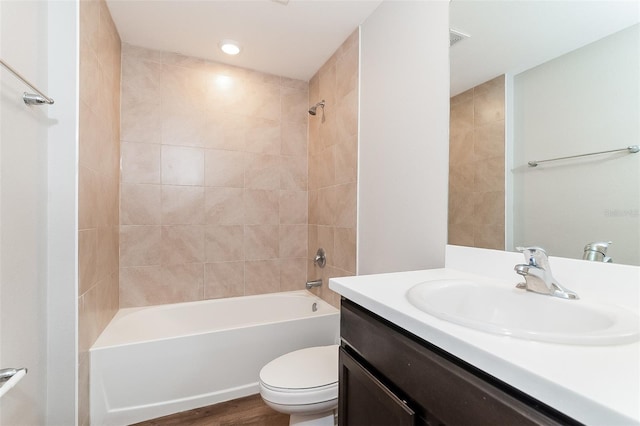 full bathroom featuring hardwood / wood-style flooring, vanity, toilet, and tiled shower / bath combo