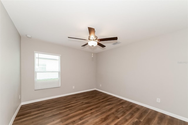 spare room with dark wood-type flooring and ceiling fan