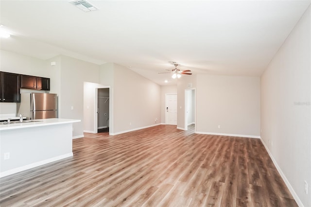 unfurnished living room with light wood-type flooring, sink, and ceiling fan