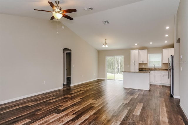 unfurnished living room with dark wood-type flooring, a wealth of natural light, and ceiling fan