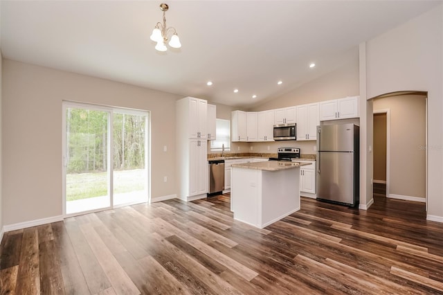 kitchen with stainless steel appliances, white cabinets, dark hardwood / wood-style floors, a kitchen island, and pendant lighting