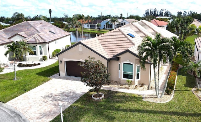 view of front of home featuring a garage, a water view, and a front yard