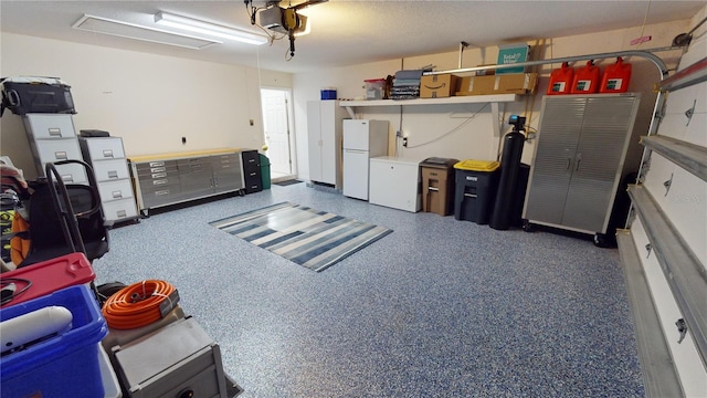 garage featuring white refrigerator and a garage door opener