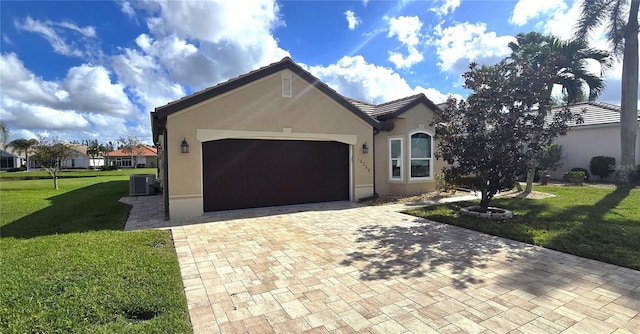 ranch-style house featuring a garage, a front yard, and central AC