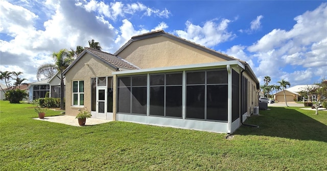 back of property with a sunroom and a yard