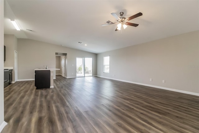 unfurnished living room featuring dark hardwood / wood-style flooring, lofted ceiling, sink, and ceiling fan