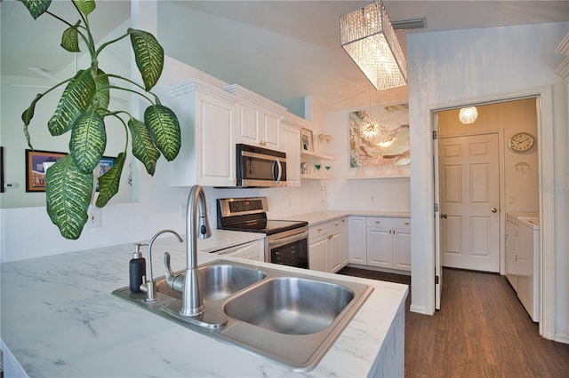 kitchen featuring white cabinetry, sink, kitchen peninsula, stainless steel appliances, and washer and clothes dryer