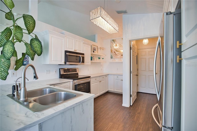 kitchen with appliances with stainless steel finishes, decorative light fixtures, white cabinetry, sink, and dark wood-type flooring