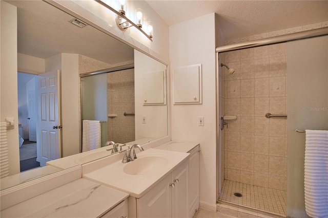 bathroom with vanity, a textured ceiling, and walk in shower