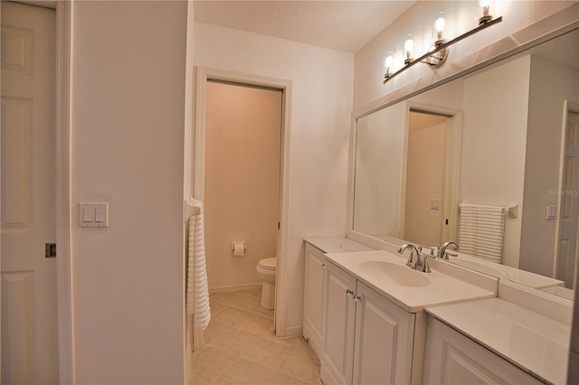 bathroom featuring tile patterned floors, vanity, toilet, and a textured ceiling