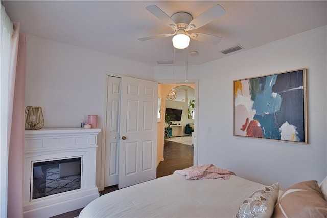 bedroom with dark wood-type flooring, a closet, and ceiling fan