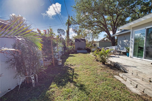 view of yard featuring a storage unit and a patio