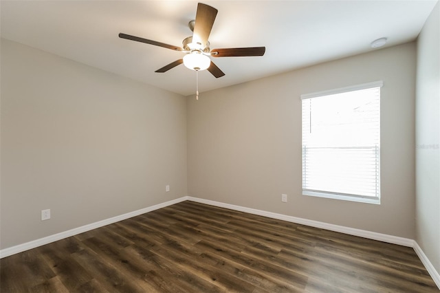 empty room featuring dark hardwood / wood-style flooring, a healthy amount of sunlight, and ceiling fan