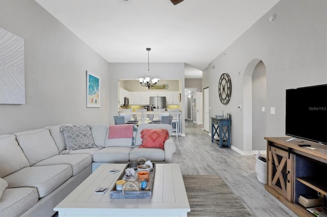 living room featuring a notable chandelier and light wood-type flooring