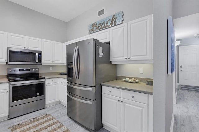 kitchen featuring white cabinets, stainless steel appliances, and light hardwood / wood-style floors