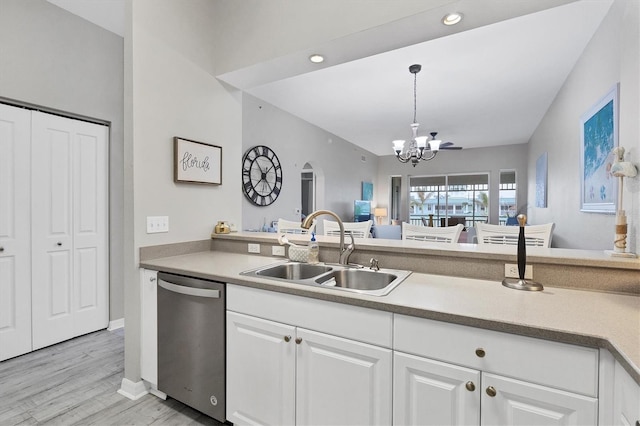 kitchen featuring sink, white cabinets, stainless steel dishwasher, and light hardwood / wood-style flooring