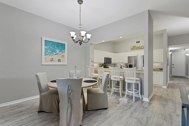 dining area featuring light hardwood / wood-style floors and a chandelier