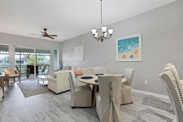 dining room featuring ceiling fan with notable chandelier and light hardwood / wood-style flooring